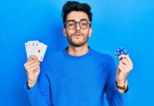 Odds, underdog, spins: entenda o vocabulário básico do mundo do cassino online homem mostrando baralho e ficha de poker