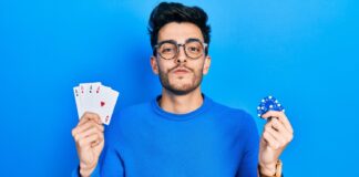 homem mostrando baralho e ficha de poker