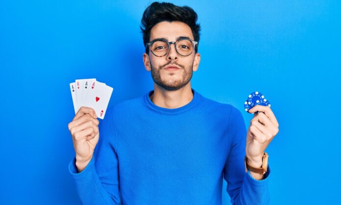 Odds, underdog, spins: entenda o vocabulário básico do mundo do cassino online homem mostrando baralho e ficha de poker