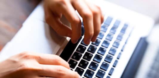 Verbo to call: O que significa e como usar Imagem de uma pessoa estudando o Verbo to call em seu computador