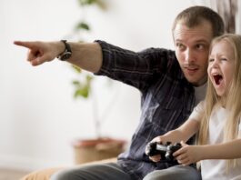 Homem ensinando a filha como aprender inglês com videogames
