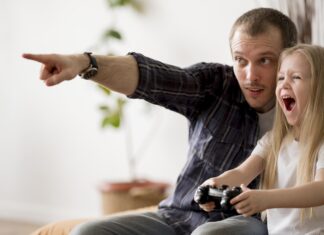 Homem ensinando a filha como aprender inglês com videogames