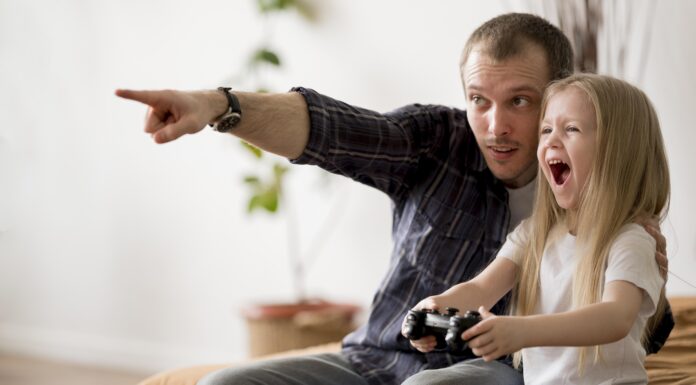 Homem ensinando a filha como aprender inglês com videogames