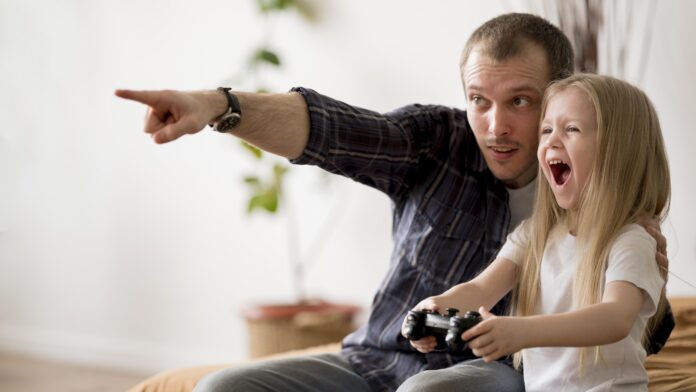 Homem ensinando a filha como aprender inglês com videogames