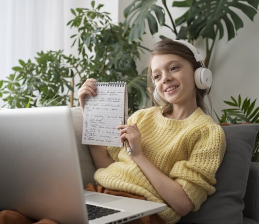 Menina pesquisando em seu notebook como aprender inglês em casa