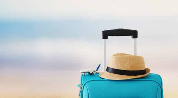 Imagem de uma mala em uma praia representando as férias e feriados em inglês